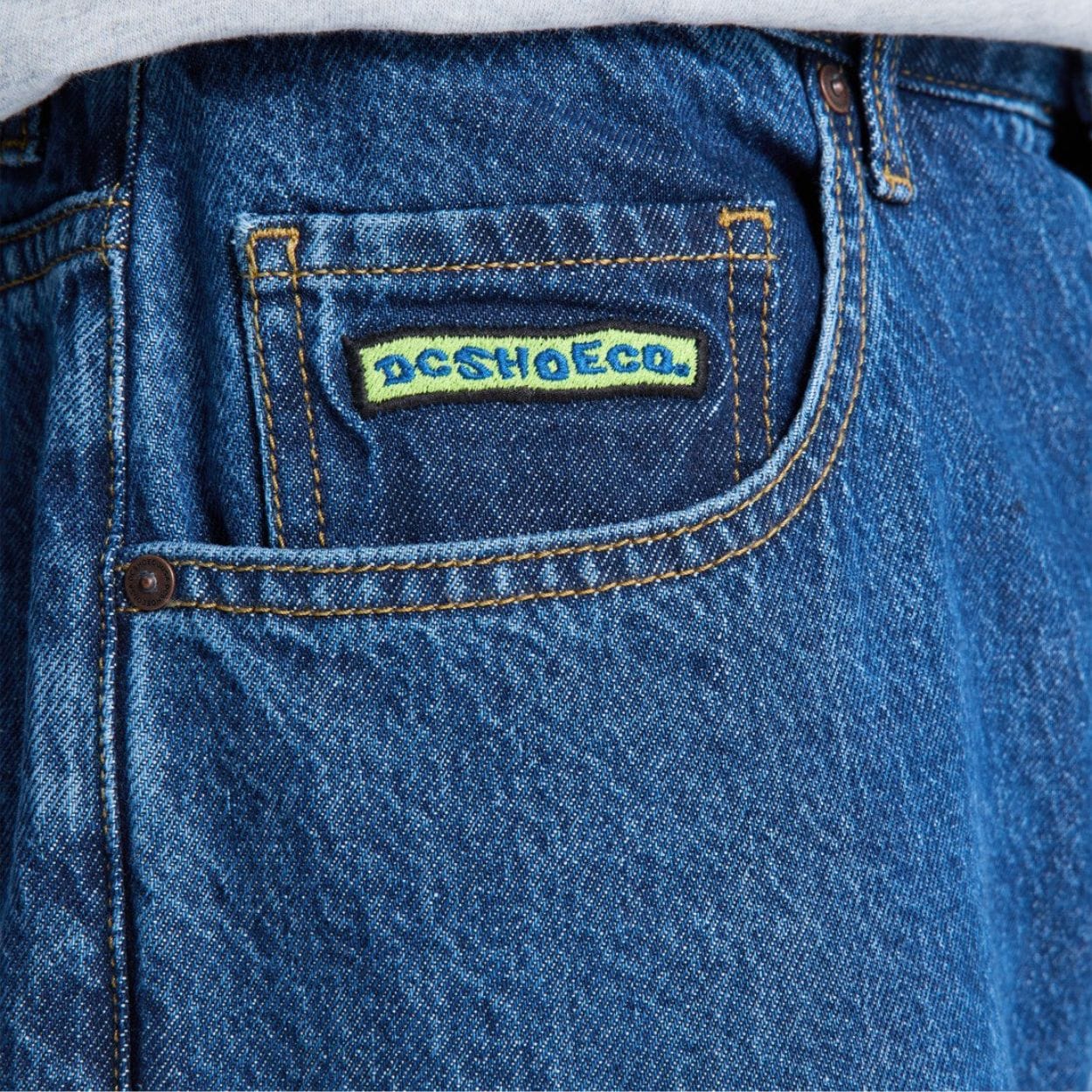 Blue DC Baggy Denim Jeans displayed with relaxed fit, classic five-pocket design, and brand logo on the back pocket.