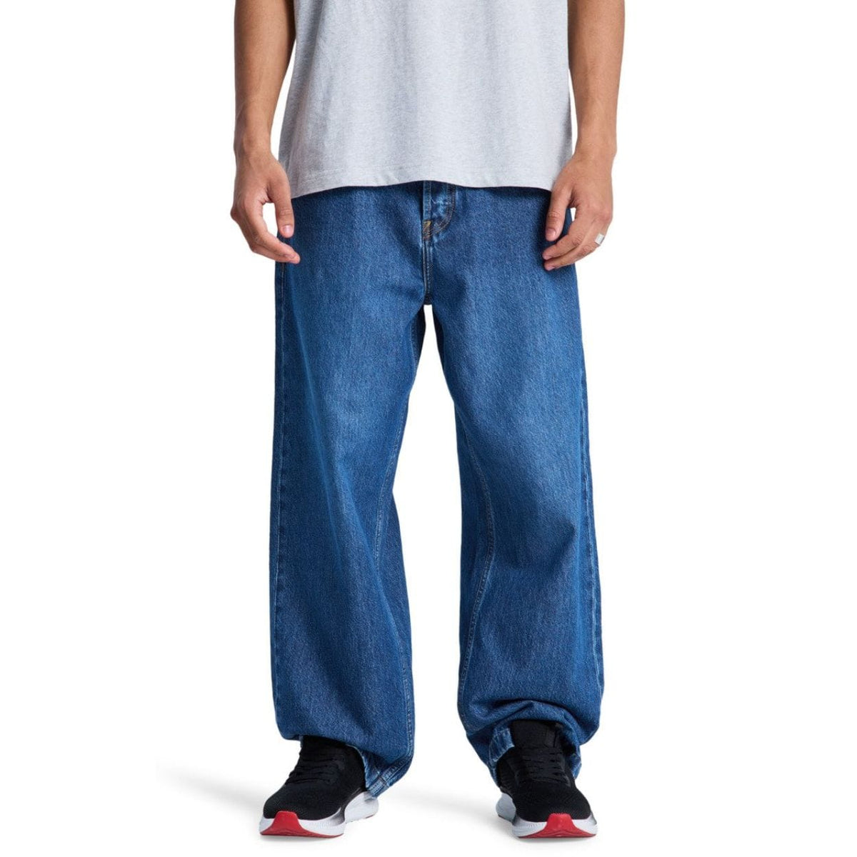 Blue DC Shoes Baggy Denim Jeans with relaxed fit and classic five-pocket design, shown hanging on a wooden background.