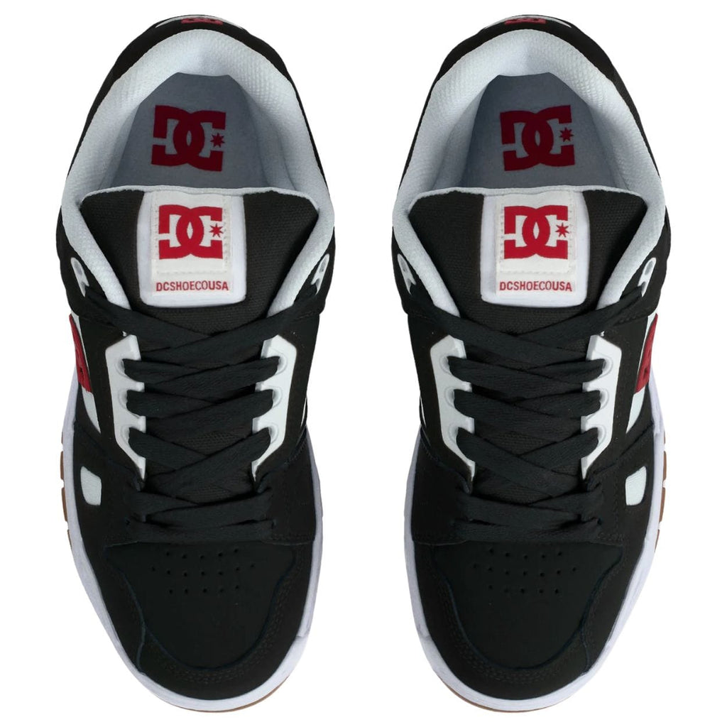 DC Stag skate shoes in black, white, and red with classic skate shoe design and logo details, suitable for skateboarding and casual wear.