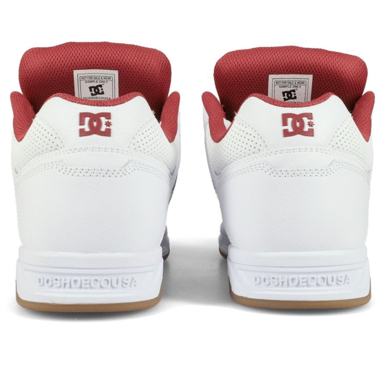 White DC Stag skate shoes with black accents, featuring classic low-top design and durable rubber soles.