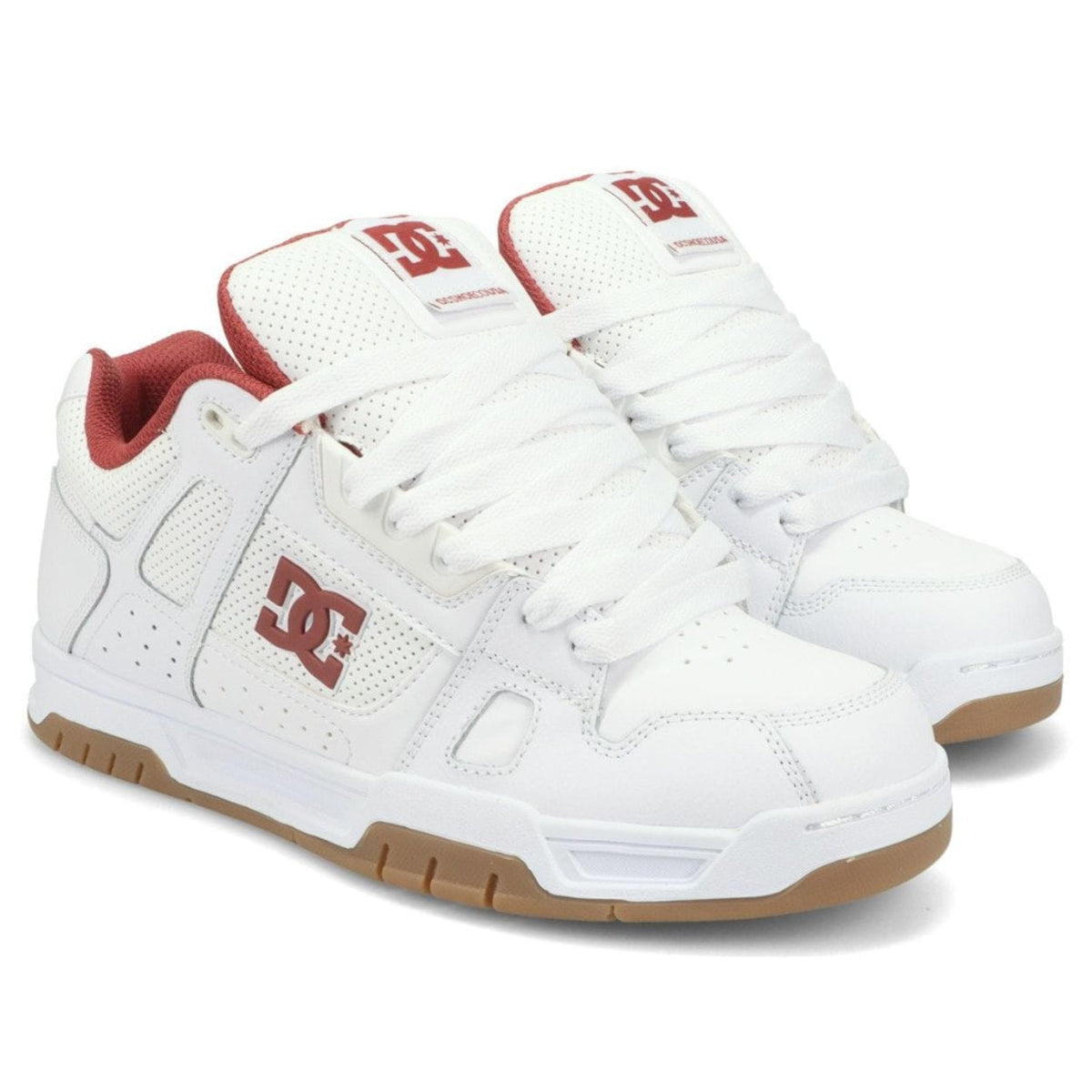 White DC Stag skate shoes with black accents, featuring classic low-top design and skateboarding grip sole.