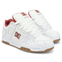 White DC Stag skate shoes with black accents, featuring classic low-top design and skateboarding grip sole.