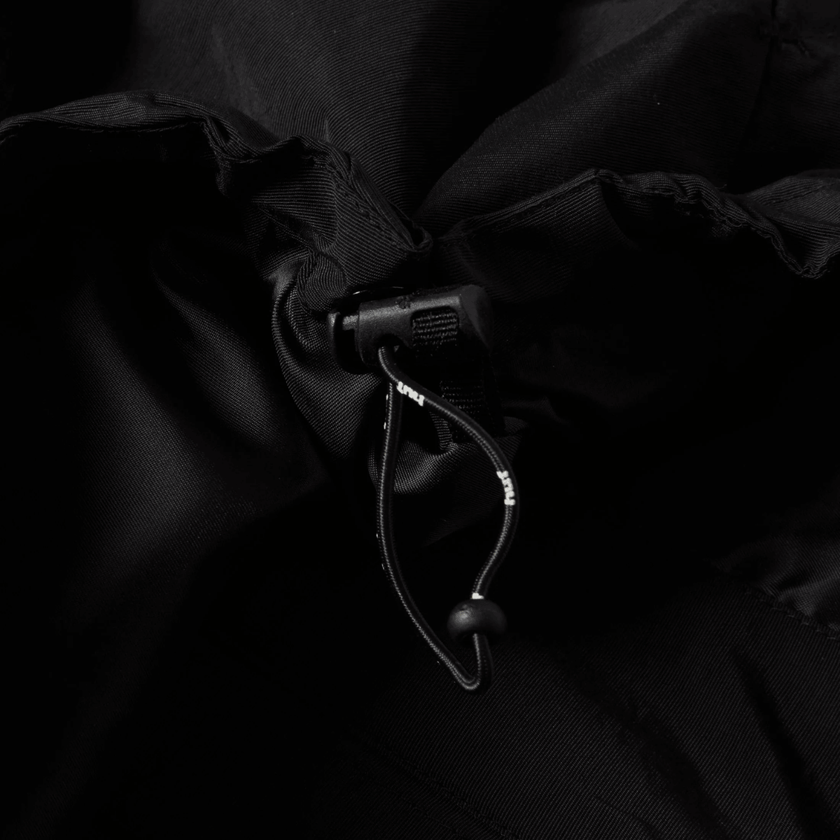 HUF All Caps Shell Jacket in black, lightweight waterproof jacket with hood and zippered pockets, stylish outerwear for men.