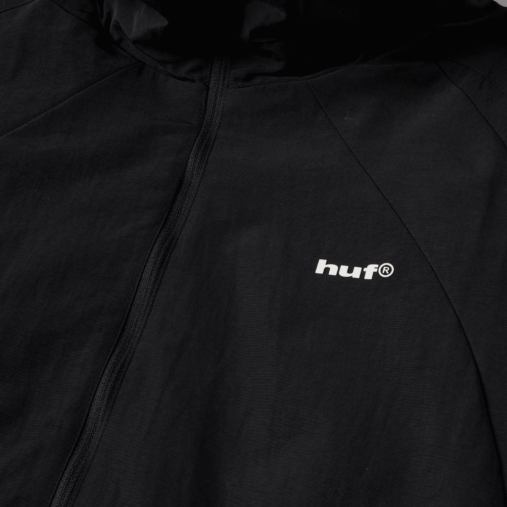 Black HUF All Caps Shell Jacket with a sleek design, featuring a hood and zippered front for a versatile, stylish look.