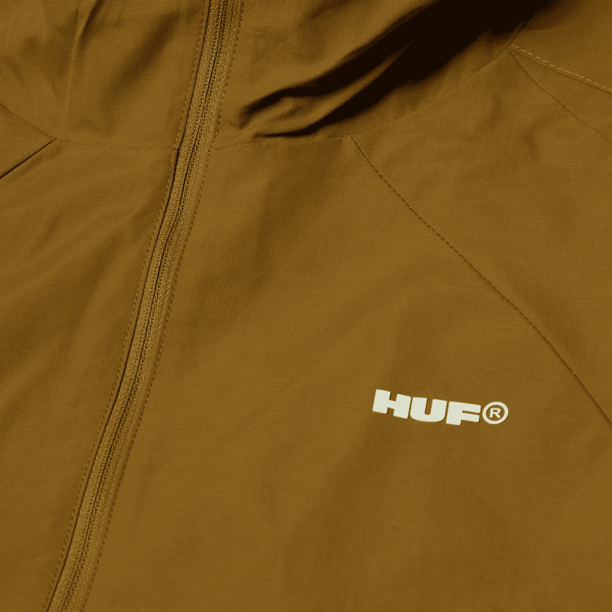HUF All Caps Shell Jacket in rich brown, lightweight jacket with hood, waterproof material, and front zip closure.