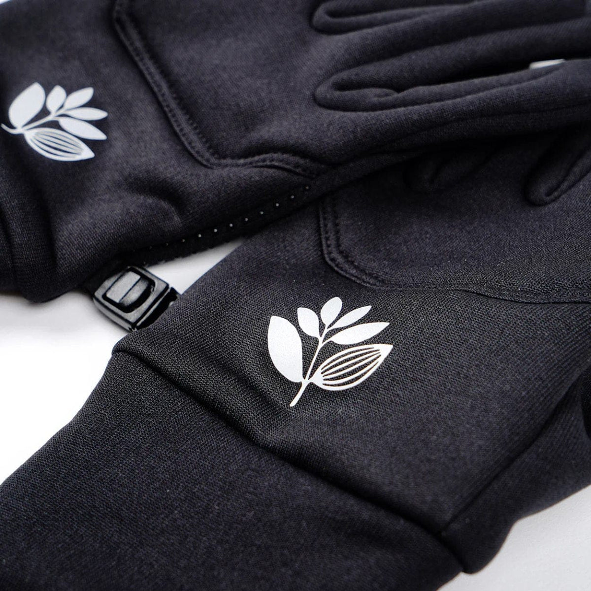 Magenta Skateboards Neo Gloves in black, showing padded skateboarding gloves with Magenta branding and adjustable wrist straps.